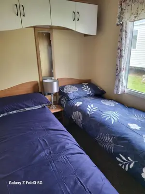 a bedroom with two beds and a window at Home from home in Holland-on-Sea