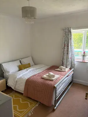 a bedroom with a bed with two towels on it at Next to double Nobel Laureate in Trumpington