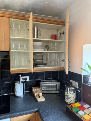 a kitchen with cabinets with glasses and dishes in it at Next to double Nobel Laureate in Trumpington