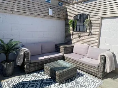 a patio with two wicker chairs and a table at Sanctuary Rooms in Brightlingsea