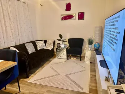a living room with a couch and a tv at Home in Cambridge in Long Stanton