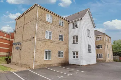 a large brick building next to a parking lot at Spacious 3 bed flat in Colchester - Free parking in Hythe