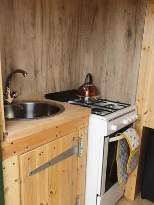 a kitchen with a sink and a stove at Delightful shepherd's hut in a rural location in North Fambridge