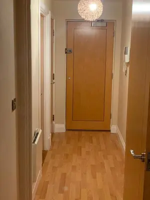 a hallway with a brown door and a wooden floor at Two Bed Flat By The Beach No Parties No Events in Southend-on-Sea