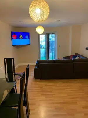 a living room with a black couch and a table at Two Bed Flat By The Beach No Parties No Events in Southend-on-Sea