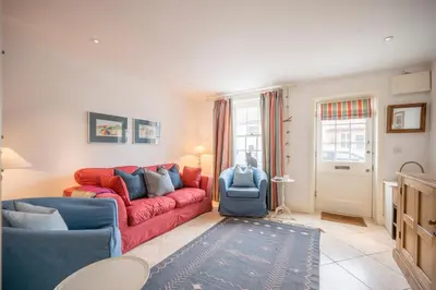 a living room with a red couch and blue chairs at 207 High Street, Aldeburgh in Aldeburgh