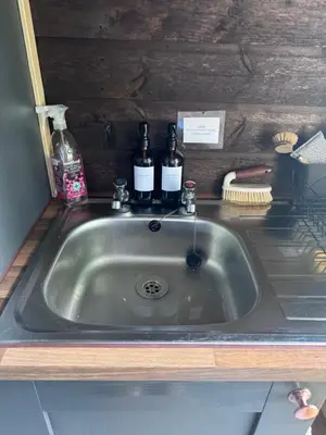 a kitchen sink with two bottles of wine on it at The Skye Yurt in Messing