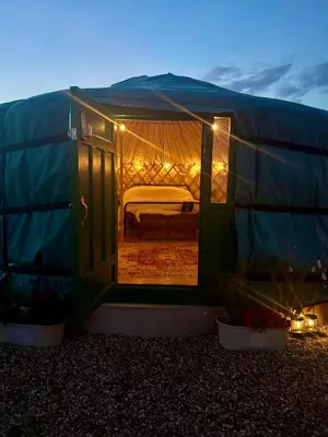 a green tent with a bed inside of it at The Skye Yurt in Messing