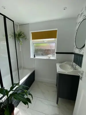 a bathroom with a sink and a mirror and a window at 5 chapel lane Wymondham Norfolk in Wymondham