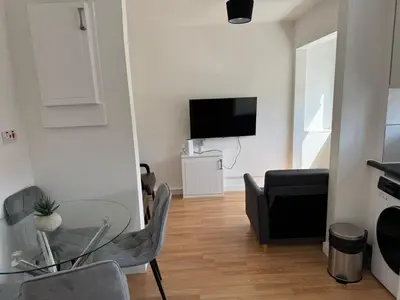 a living room with a glass table and a couch at Holly Copse in Stevenage