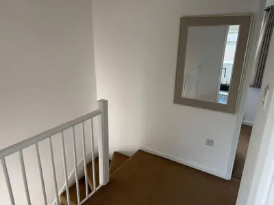 a stairway with a mirror on the wall at Holly Copse in Stevenage