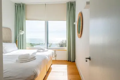 a bedroom with two beds and a large window at Heath House 4 in Thorpeness