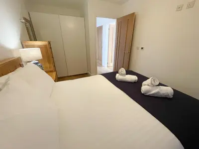 a bedroom with a large bed with towels on it at Modern stylish house in Charming Fen Ditton Village in CBG