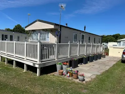 a house with a porch and potted plants in front of it at Perfect days away - 3 bedroom 1 shower with decking & bedding in Colchester
