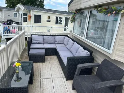 a patio with a couch and chairs on a porch at Perfect days away - 3 bedroom 1 shower with decking & bedding in Colchester