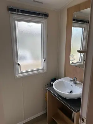 a bathroom with a sink and a window at Perfect days away - 3 bedroom 1 shower with decking & bedding in Colchester