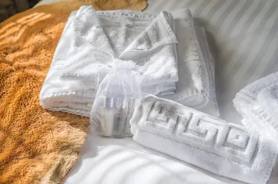 a pile of towels and a bottle on a bed at Huge 8 Bed Manor House with Hot Tub, Cinema Room, Games Room in Hailsham