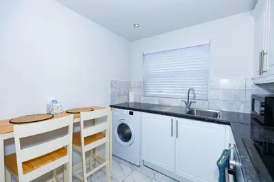 a kitchen with a sink and a washing machine at First Class Flat in Brandon