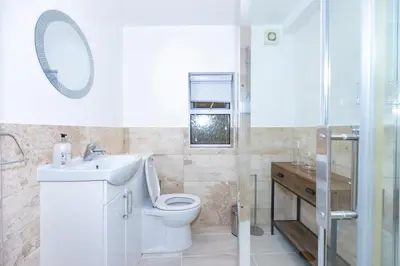 a bathroom with a toilet and a sink and a shower at First Class Flat in Brandon