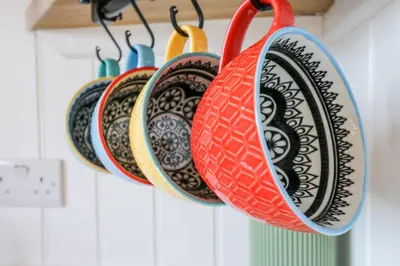 a bunch of plates are hanging on a rack at Woodpecker in Cambridge