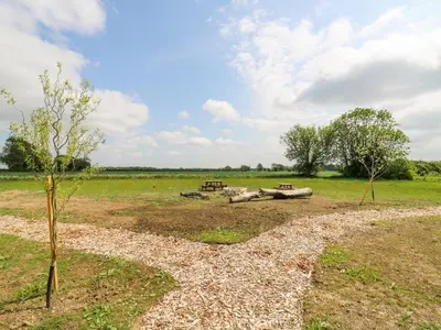 a field with a picnic table and trees in it at Woodpecker in Cambridge