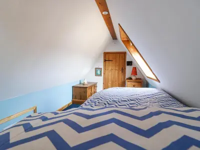 a bedroom with a blue and white bed in a room at Kingfisher in Ely