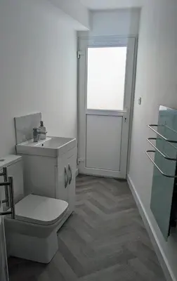 a white bathroom with a toilet and a window at The Southend Airport Lodge in Southend-on-Sea
