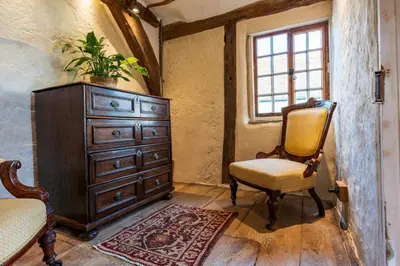 a bedroom with a dresser and a chair and a window at Taper House - Cosy Medieval Cottage in Kersey