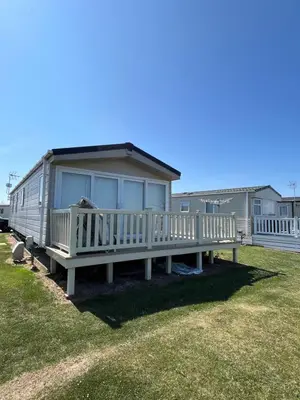 a manufactured home with a porch and a house at Verb View 6 Berth Caravan St Osyth Clacton-On-Sea in Saint Osyth