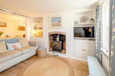 a living room with a couch and a fireplace at Seahorse Cottage, Aldeburgh - sleeps 4 - Adult only property - Managed by Aldeburgh Coastal Cottages in Aldeburgh