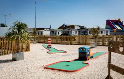 a playground with two play equipment in a yard at Dancing Seagulls Caravan in Clacton-on-Sea