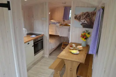 a small kitchen with a table in a tiny house at Shepherds Hut 5 in Woodbridge