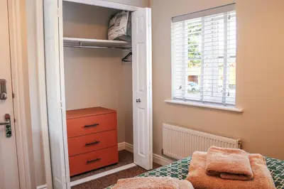 a bedroom with a bed with a dresser and a window at Stylish 2 Bedroom Property in Bury Saint Edmunds