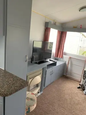 a living room with a tv and a fireplace at Seawick holiday park caravan in Saint Osyth