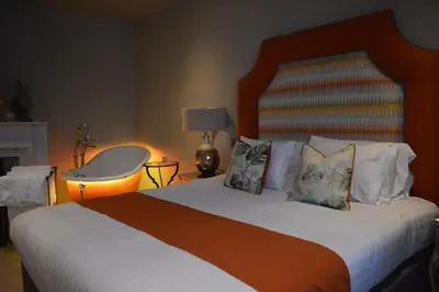 a bedroom with a large bed with white sheets and pillows at Long Melford Swan in Long Melford