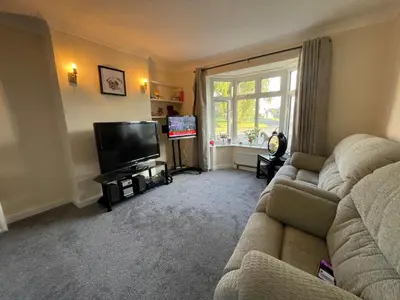 a living room with a couch and a flat screen tv at Ouse River Quay Hill Lodge in Littleport