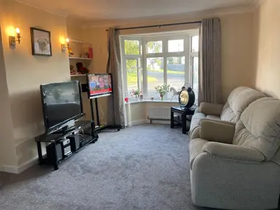 a living room with a couch and a television at Ouse River Quay Hill Lodge in Littleport