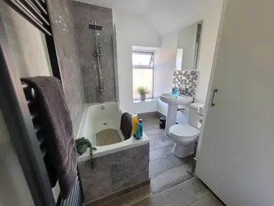 a bathroom with a tub and a toilet and a sink at Pet Friendly 2-Bed Home Near Marina & Town - Free Parking in Ipswich