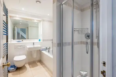 a bathroom with a shower and a toilet and a sink at Samphire in Aldeburgh