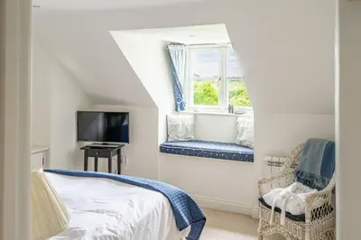 a bedroom with a bed and a window at Samphire in Aldeburgh