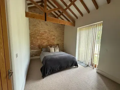 a bedroom with a bed and a brick wall at The Old stables Barn in Old Hurst