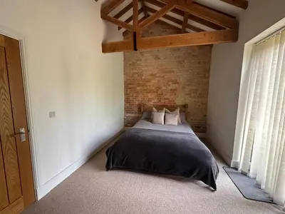 a bedroom with a bed and a brick wall at The Old stables Barn in Old Hurst