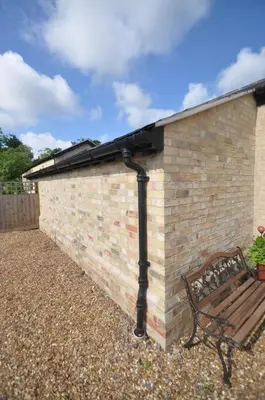 a brick building with a bench next to it at The Old stables Barn in Old Hurst