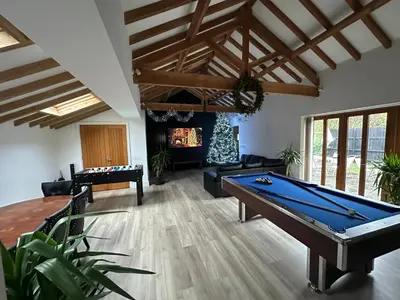 a living room with a pool table and a fireplace at The Old stables Barn in Old Hurst