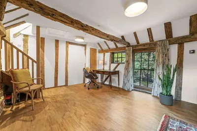 a living room with wooden floors and a desk at Luces Loft in Castle Hedingham