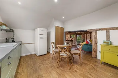 a kitchen with a table and chairs in a kitchen at Luces Loft in Castle Hedingham