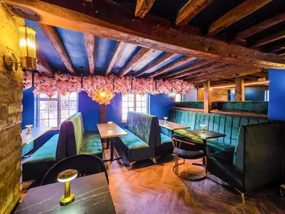 a restaurant with blue walls and tables and chairs at The Courtyard Lodge in Hitchin