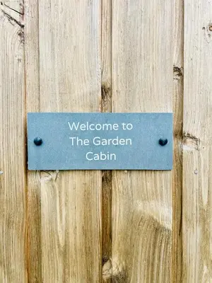 a sign on a wooden door with the words welcome to the garden cabin at Romantic Cabin Retreat on 50-Acre Suffolk Farm in Burgh