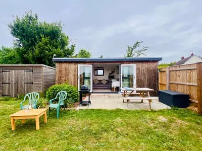 a backyard with a shed with a table and chairs at Romantic Cabin Retreat on 50-Acre Suffolk Farm in Burgh