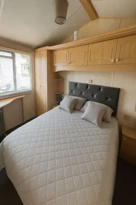 a bedroom with a large bed in a trailer at Rohannah A&C Ultimate Caravan Retreat in East Mersea
